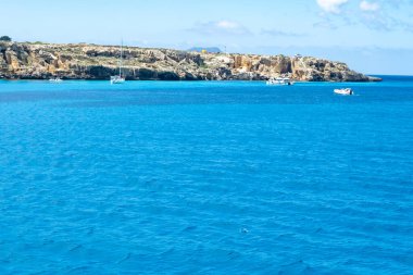 Trapani 'den tekne gezisi ve açık turkuvaz suyu, tuff kayaları, terk edilmiş taş ocakları, Sicilya, İtalya yakınlarındaki Egadi Adaları ile birlikte Favignana adasının kıyı şeridi manzarası.