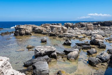 Favignana adasının kıyı şeridi, tuff kayaları, kültürel miras terk edilmiş taş ocakları, mağaralar, antik kalenit çıkarması, inşa için kullanılan taş, Sicilya, İtalya yakınlarındaki Egadi Adaları, tekne gezisi.