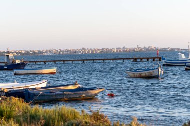 Marsala Stagnone sularında gün batımı, Marsala, Sicilya, İtalya yakınlarındaki tuzlu lagün ve doğa rezervi, sığ, ılık su, tuz tavaları, antik yel değirmenleri ile eşsiz ekosistem