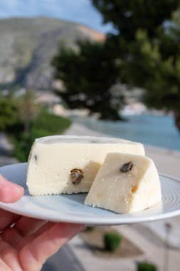 Primo İndirimli Sert Peynir. Karışık sütten yapılmış. Sicilya sepetinin ince kabuğu ve deseni turşulu kapari ve Sicilya, Mondello sahilinde deniz manzaralı.