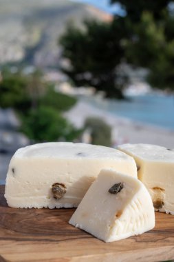 Primo İndirimli Sert Peynir. Karışık sütten yapılmış. Sicilya sepetinin ince kabuğu ve deseni turşulu kapari ve Sicilya, Mondello sahilinde deniz manzaralı.