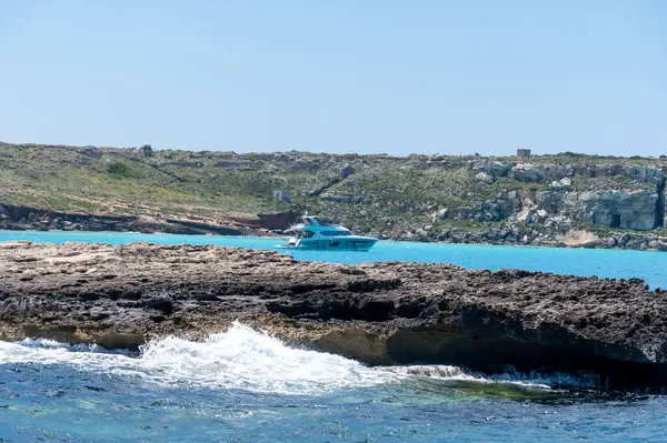 Trapani 'den tekne gezisi ve açık turkuvaz suyu, tuff kayaları, terk edilmiş taş ocakları, Sicilya, İtalya yakınlarındaki Egadi Adaları ile birlikte Favignana adasının kıyı şeridi manzarası.