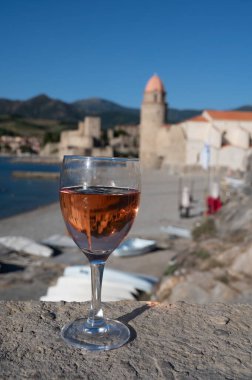 Eski Collioure kasabası manzaralı iki bardak gül Collioure AOC şarabı, renkli evler, kilise, kale ve plajlar, Occitanie, Fransa, turist beldesi