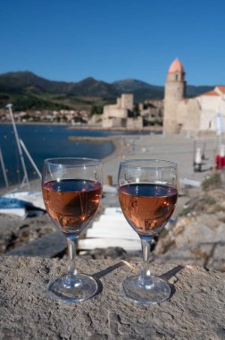 Eski Collioure kasabası manzaralı iki bardak gül Collioure AOC şarabı, renkli evler, kilise, kale ve plajlar, Occitanie, Fransa, turist beldesi