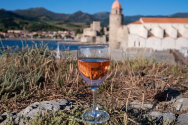 Bir bardak gül Collioure AOC şarabı eski şehir Collioure manzaralı, renkli evler, kilise, kale ve plajlar, Occitanie, Fransa, turist beldesi