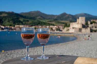Eski Collioure kasabası manzaralı iki bardak gül Collioure AOC şarabı, renkli evler, kilise, kale ve plajlar, Occitanie, Fransa, turist beldesi