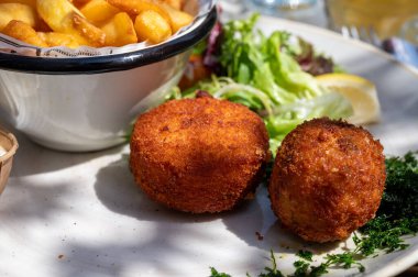 Açık kafede öğle yemeği. Vejetaryen peyniri ve yeşil kuşkonmaz kroket yanında taze salata ve Belçika, Bruges 'de patates kızartması.