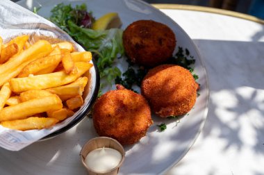 Açık kafede öğle yemeği. Vejetaryen peyniri ve yeşil kuşkonmaz kroket yanında taze salata ve Belçika, Bruges 'de patates kızartması.