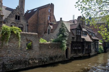 Bruges, Flanders, Belçika 'daki eski ortaçağ binalarının kanalı, köprüsü ve ön cepheleri güneşli bir günde gidilecek yer.