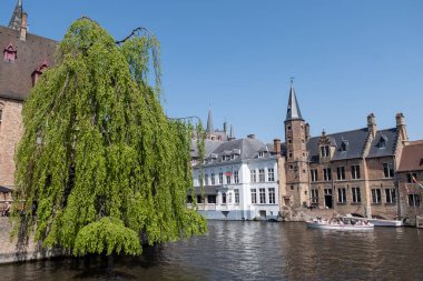 Bruges, Flanders, Belçika 'daki eski ortaçağ binalarının kanalı, köprüsü ve ön cepheleri güneşli bir günde gidilecek yer.