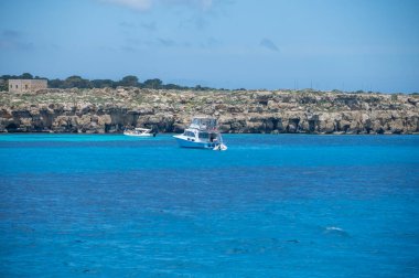 Trapani 'den tekne gezisi ve açık turkuvaz suyu, tuff kayaları, terk edilmiş taş ocakları, Sicilya, İtalya yakınlarındaki Egadi Adaları ile birlikte Favignana adasının kıyı şeridi manzarası.