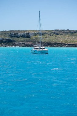 Trapani 'den tekne gezisi ve açık turkuvaz suyu, tuff kayaları, terk edilmiş taş ocakları, Sicilya, İtalya yakınlarındaki Egadi Adaları ile birlikte Favignana adasının kıyı şeridi manzarası.