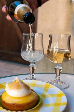 Bir Fransız limonlu turta ya da beyaz yumurtalı turta ve şampanyalı bardak köpüklü şarap, lezzetli tatlı, Fransız mutfağı.