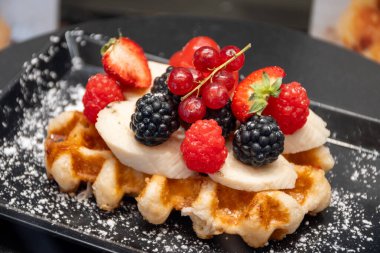 Brüksel, Flanders, Belçika 'da çeşitli malzemelerle pişirilmiş Belçika şekerli waffle' lar, lezzetli sokak yemekleri.