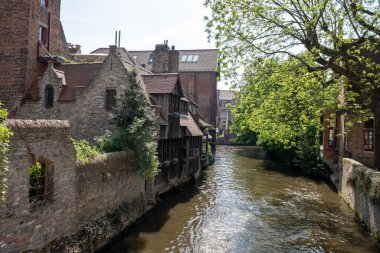 Bruges, Flanders, Belçika 'daki eski ortaçağ binalarının kanalı, köprüsü ve ön cepheleri güneşli bir günde gidilecek yer.