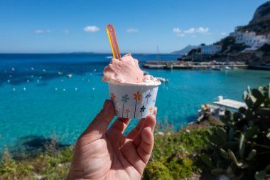 Levanza adasının mavi körfezi manzaralı taze dondurma yemek Sicilya, İtalya yakınlarındaki Egadi 'de mutlu yaz tatilleri.