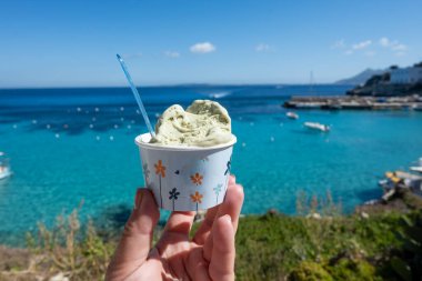 Levanza adasının mavi körfezi manzaralı taze dondurma yemek Sicilya, İtalya yakınlarındaki Egadi 'de mutlu yaz tatilleri.