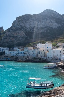 Levanzo, Egadi Adaları 'nın en küçüğü, Sicilya yakınlarında sakin bir inziva yeri, liman çevresindeki pitoresk köy, beyaz evler ve büyüleyici açık mavi su limanı, seyahat yeri, tekne gezisi.