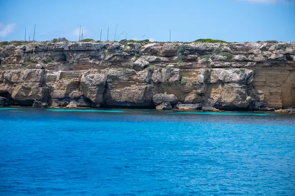 Trapani 'den tekne gezisi ve açık turkuvaz suyu, tuff kayaları, terk edilmiş taş ocakları, Sicilya, İtalya yakınlarındaki Egadi Adaları ile birlikte Favignana adasının kıyı şeridi manzarası.