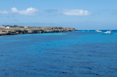 Trapani 'den tekne gezisi ve açık turkuvaz suyu, tuff kayaları, terk edilmiş taş ocakları, Sicilya, İtalya yakınlarındaki Egadi Adaları ile birlikte Favignana adasının kıyı şeridi manzarası.