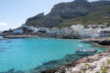 Levanzo, Egadi Adaları 'nın en küçüğü, Sicilya yakınlarında sakin bir inziva yeri, liman çevresindeki pitoresk köy, beyaz evler ve büyüleyici açık mavi su limanı, seyahat yeri, tekne gezisi.