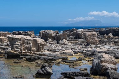 Favignana adasının kıyı şeridi, tuff kayaları, kültürel miras terk edilmiş taş ocakları, mağaralar, antik kalenit çıkarması, inşa için kullanılan taş, Sicilya, İtalya yakınlarındaki Egadi Adaları, tekne gezisi.
