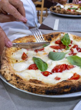 İtalyan pizzacıda fırın fırını, fırın, pizza ve pizza yemek. Kapatın.