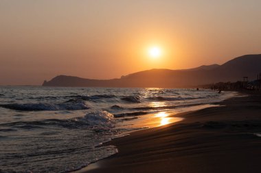 Güneş ışığında gün batımında yüzen insanların siluetleri, Sperlonga yakınlarındaki kumlu plajlar, Lazio, İtalya, yaz tatili