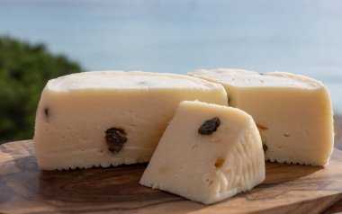 Primo İndirimli Sert Peynir. Karışık sütten yapılmış. Sicilya sepetinin ince kabuğu ve deseni turşulu kapari ve Sicilya, Mondello sahilinde deniz manzaralı.