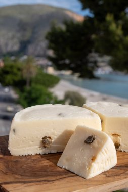 Primo İndirimli Sert Peynir. Karışık sütten yapılmış. Sicilya sepetinin ince kabuğu ve deseni turşulu kapari ve Sicilya, Mondello sahilinde deniz manzaralı.