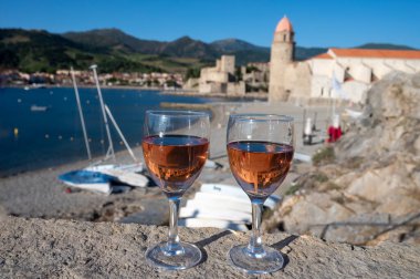 Eski Collioure kasabası manzaralı iki bardak gül Collioure AOC şarabı, renkli evler, kilise, kale ve plajlar, Occitanie, Fransa, turist beldesi