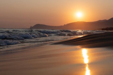Güneş ışığında gün batımında yüzen insanların siluetleri, Sperlonga yakınlarındaki kumlu plajlar, Lazio, İtalya, yaz tatili