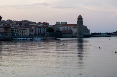 Deniz kenarında akşam manzarası, Collioure 'un eski kasabasının ışıkları ve renkli evleri, Cote Vermeille, Pyrenees-Orientales, Occitania, Fransa. Yaz tatili