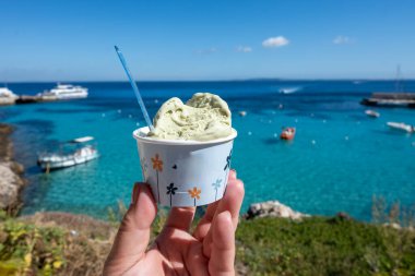 Levanza adasının mavi körfezi manzaralı taze dondurma yemek Sicilya, İtalya yakınlarındaki Egadi 'de mutlu yaz tatilleri.