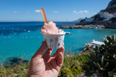 Levanza adasının mavi körfezi manzaralı taze dondurma yemek Sicilya, İtalya yakınlarındaki Egadi 'de mutlu yaz tatilleri.