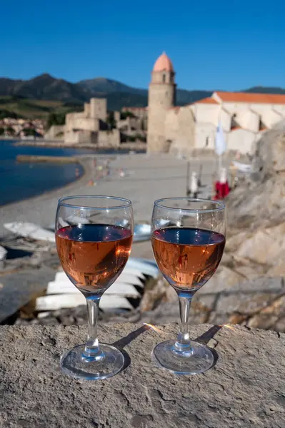 Eski Collioure kasabası manzaralı iki bardak gül Collioure AOC şarabı, renkli evler, kilise, kale ve plajlar, Occitanie, Fransa, turist beldesi