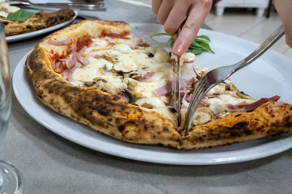 İtalyan pizzacıda fırın fırını, fırın, pizza ve pizza yemek. Kapatın.