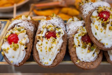 Ev yapımı tatlı cannolo sfoglie tatlı badem, şam fıstığı, limon, vanilya, çikolata kreması Palermo, Sicilya, İtalya 'da sokak yiyecekleri pazarında