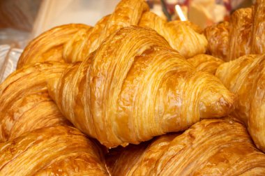 Sabah tereyağlı kruvasan ve çikolatalı kruvasanlar Tpulouse, Fransa 'daki zanaat fırınında sergileniyor.