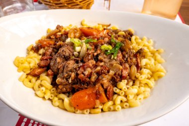 Fransa 'nın Toulouse kentindeki geleneksel balık restoranında pişmiş makarna ile servis edilen taze et parçaları, havuç ve mantarla ünlü Fransız yemeği.
