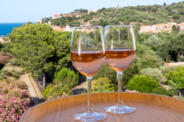 Akdeniz 'de yaz tatili, güneş ışığı ve deniz manzarasında soğuk gül şarabı içmek, Collioure, Occitanie, Güney Fransa, turist beldesi