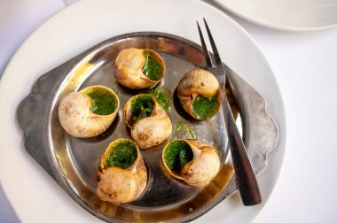 Burgundy 'den maydanozlu salyangoz ve sarımsaklı tereyağı ile fırın Toulouse veya Paris' teki Fransız restoranında başlangıç yemeği olarak servis edilir.