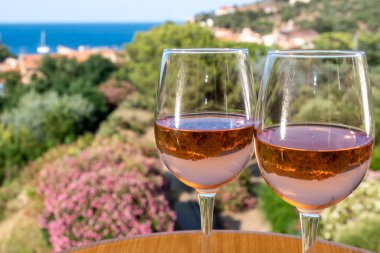 Akdeniz 'de yaz tatili, güneş ışığı ve deniz manzarasında soğuk gül şarabı içmek, Collioure, Occitanie, Güney Fransa, turist beldesi