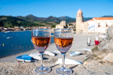 Eski Collioure kasabası manzaralı iki bardak gül Collioure AOC şarabı, renkli evler, kilise, kale ve plajlar, Occitanie, Fransa, turist beldesi