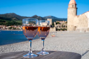 Eski Collioure kasabası manzaralı iki bardak gül Collioure AOC şarabı, renkli evler, kilise, kale ve plajlar, Occitanie, Fransa, turist beldesi
