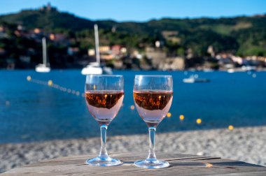 Eski Collioure kasabası manzaralı iki bardak gül Collioure AOC şarabı, renkli evler, kilise, kale ve plajlar, Occitanie, Fransa, turist beldesi