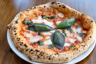 Ekşi hamurlu düz ekmek mozzarella peyniri, domates ve fesleğen yapraklı Margarita, Napoli sokak yemeği, İtalya, kapatın.