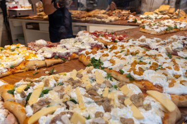 Parma, Emilia Romanya, İtalya 'daki fırında sebzeli, biberli, mantarlı, domatesli ve peynirli taze Focaccia veya pala romana pizzası sokak kafesinde sergileniyor