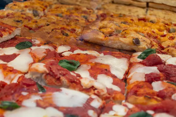 Parma, Emilia Romanya, İtalya 'daki fırında sebzeli, biberli, mantarlı, domatesli ve peynirli taze Focaccia veya pala romana pizzası sokak kafesinde sergileniyor