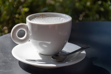 Varenna, Como Gölü, Milano, İtalya 'daki kafede servis edilen laktozsuz badem sütlü İtalyan kahvesi cappuccino içmek
